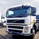 White Volvo FM 400 6x4 horse with black-and-white striped sunvisor, 400 badge visible, side profile